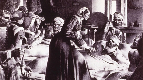 A woman tends to wounded soldiers in a dimly lit room.