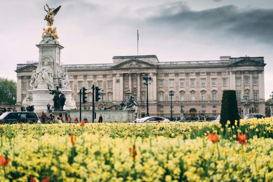Buckingham Palace with Victoria Memorial and yellow flowers in foreground.