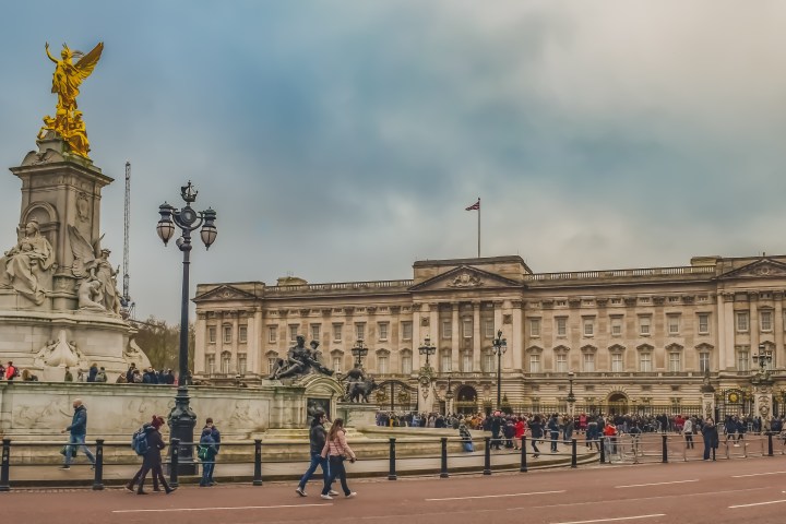 Crowd outside Buckingham Palace with the Victoria Memorial in front.