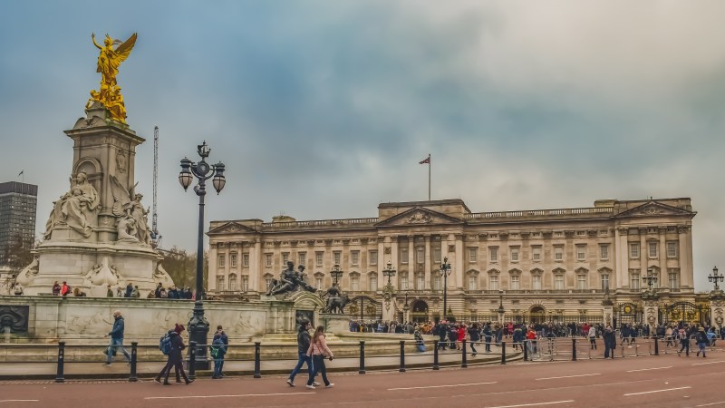 Crowd outside Buckingham Palace with the Victoria Memorial in front.
